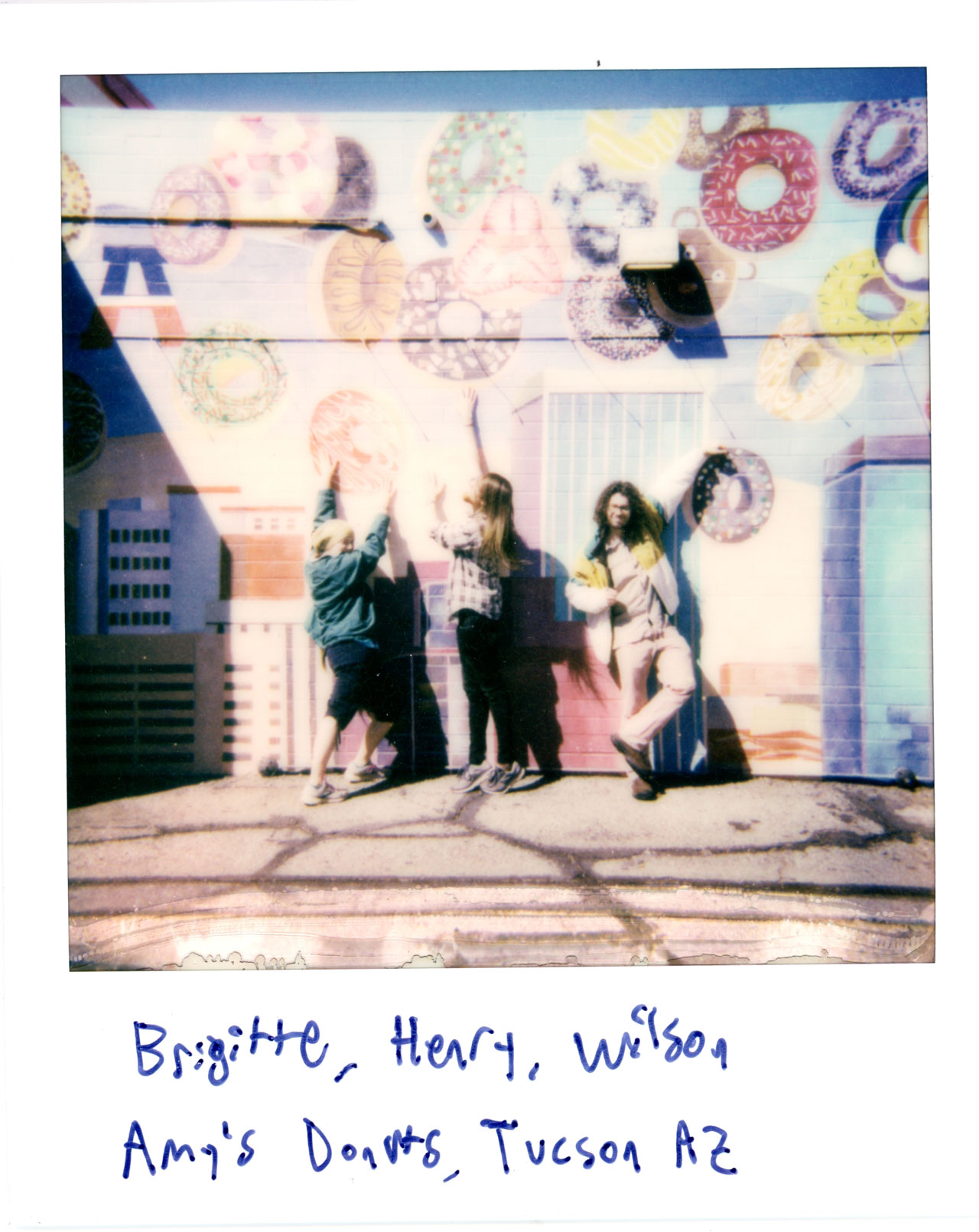 Brigitte, Henry, and Wilson in front of a mural at Amy's Donuts in Tucson, AZ